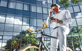 Man on who has stopped on bicycle to check phone