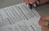 An image of someone's hand signing a document